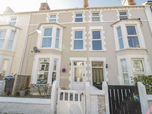 A row of terraced houses with bay windows and front gates at Lisboa in Llandudno