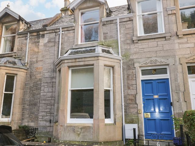 Stone exterior of a house with a blue door and large windows at 6 Coltbridge Gardens Edinburgh