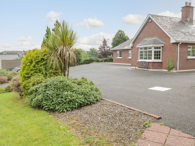 A brick house with a paved driveway and garden plants at Clodagh's Cottage in Collooney County Sligo