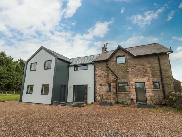 A house with a combination of modern and stone exterior walls under a partly cloudy sky at Shepherds House in Lowick