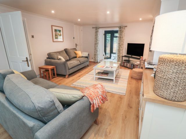 A living room with two sofas a coffee table a television and a lamp at Salt Cottage in Marske-By-The-Sea
