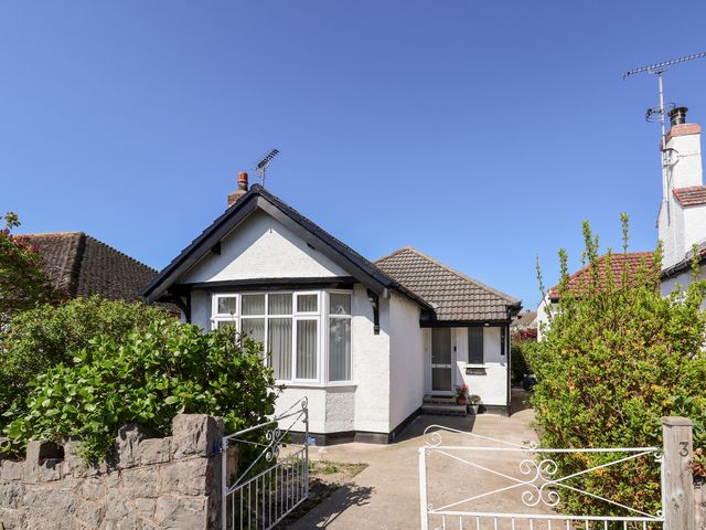 A single story house with a gated driveway and bushes at 3 Rhyd Drive in Rhos-On-Sea