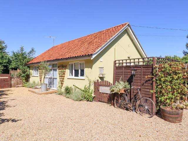 A single-story house with a tiled roof and gravel driveway with a bicycle and plants at Pantiles in Eyke near Woodbridge