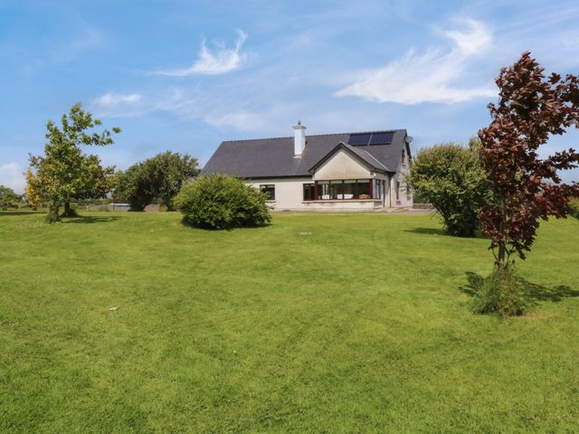 A house with a pitched roof and solar panels on a large grassy lawn with trees at Bunny Lane in Cloonflynn near Ballycarra County Mayo