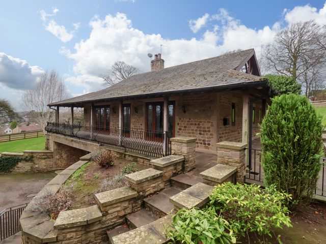 Stone house with a tiled roof and railing along a raised terrace at Sandy Gate in Farnham near Knaresborough