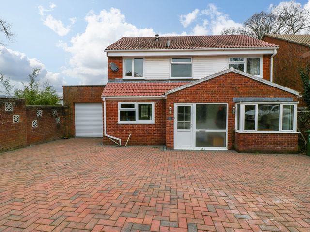 A brick house with a tiled roof a driveway and garage at 14 Birchwood Road in Woolaston