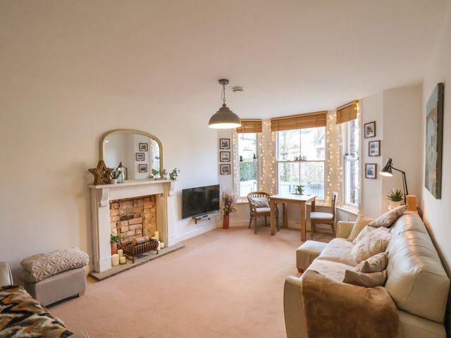 A living room with a fireplace television sofa dining table and chairs at Happy Days in Scarborough