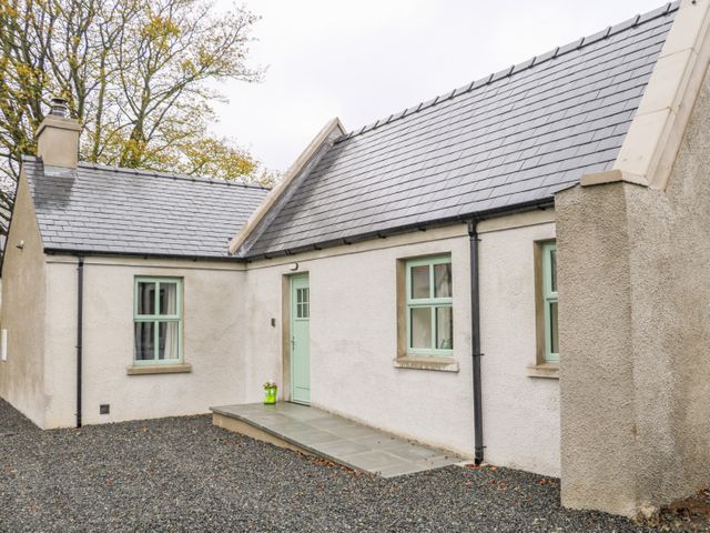 The exterior of a single story house with a slate roof light green window frames and a light green door at Minnie's Cottage Killeavy