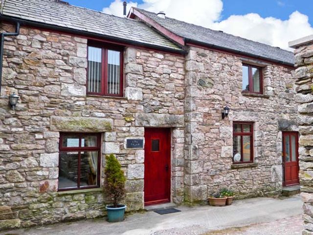 A stone house exterior with red doors and windows and potted plants at The Crook in Great Urswick near Ulverston