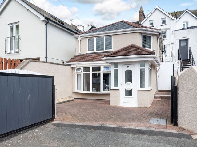 A detached house with a paved driveway and white front door at 14 Tudno Street in Llandudno