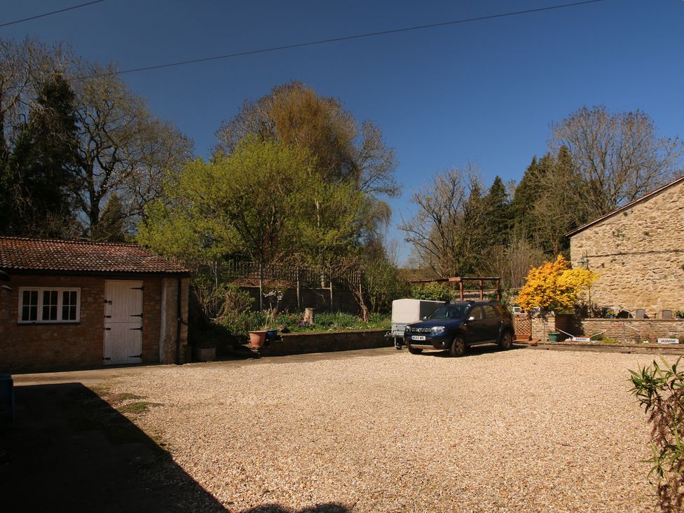An outdoor area with a gravel driveway and a car at Jasmine Cottage South Perrott near Mosterton