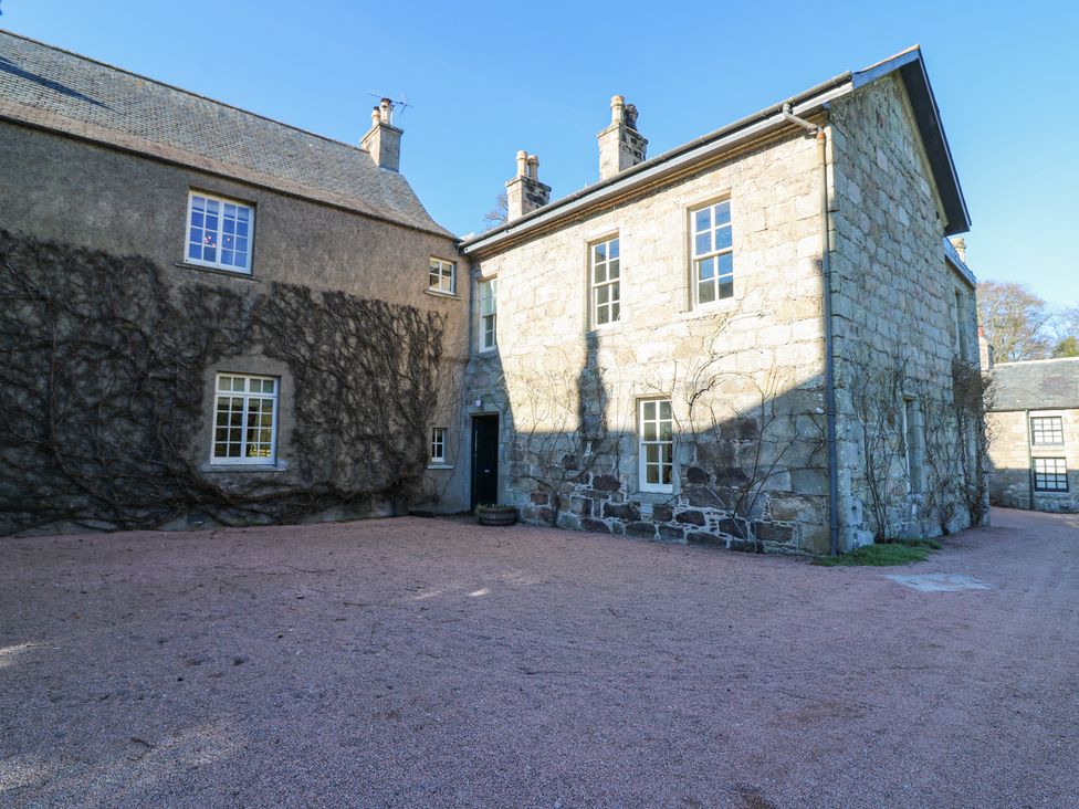 An exterior view of a stone building with windows and vines on walls at North Wing - Pitmedden Gardens in Pitmedden