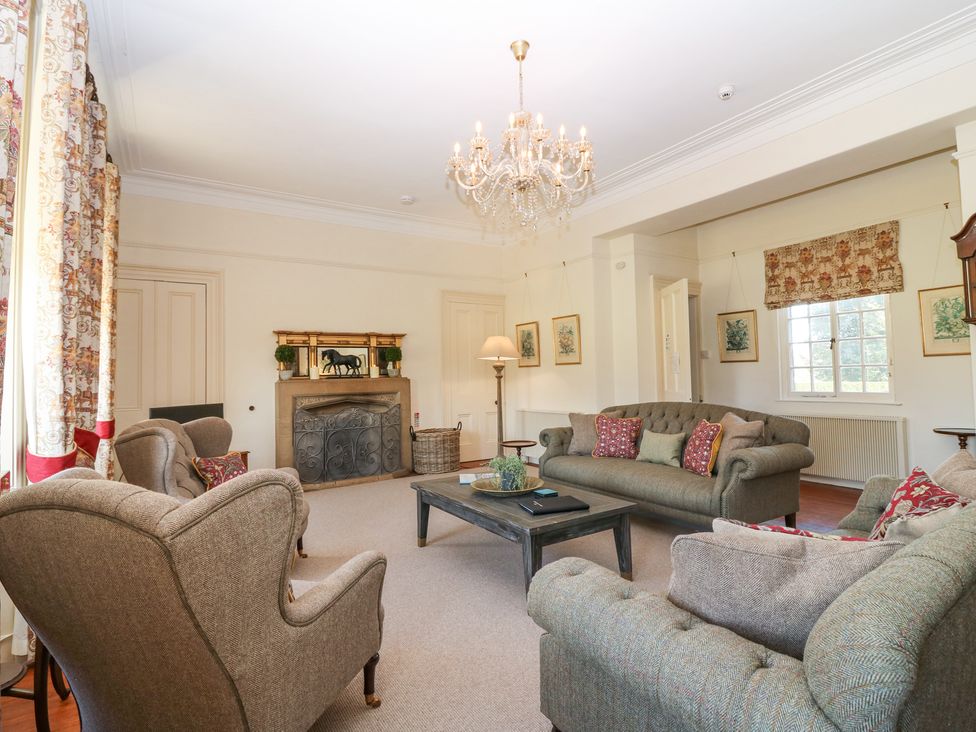 A living room with sofas armchairs a coffee table and a chandelier at North Wing - Pitmedden Gardens in Pitmedden