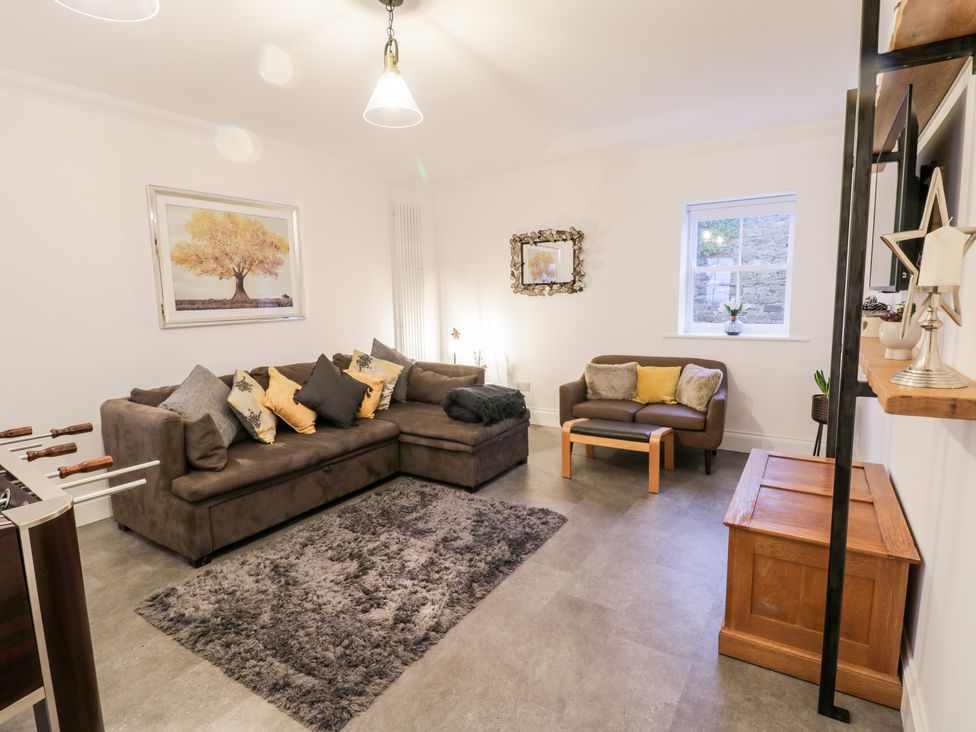 A living room with two sofas a gray rug a coffee table and wall art at Fell Briggs Cottage Marske-By-The-Sea