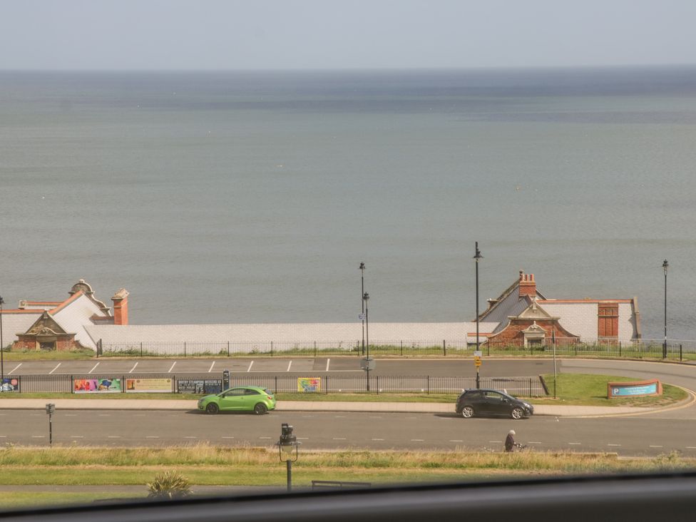 A coastal view with parked cars facing the sea at Foxton Penthouse in Whitby
