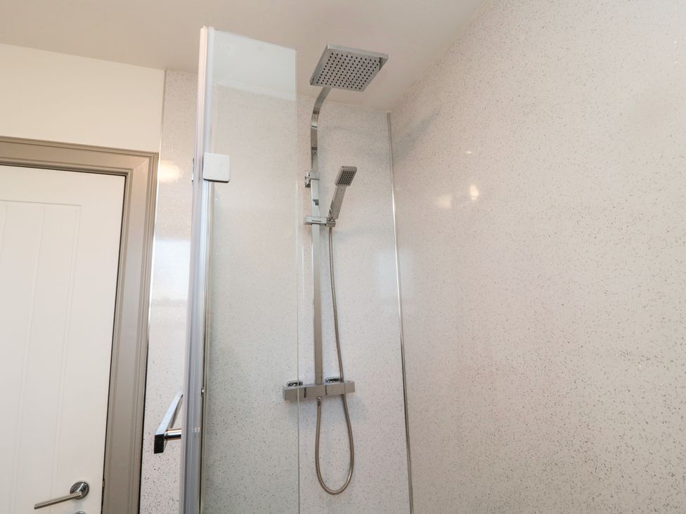 A shower area with a glass door and chrome shower fixtures at The Annexe in Berwick-Upon-Tweed