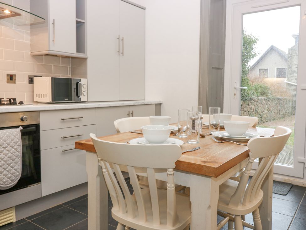 A kitchen with a wooden dining table set with bowls glasses and cutlery at 16 Main Street Newburgh near Ellon