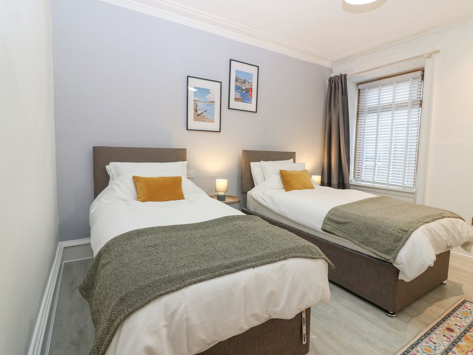 A bedroom with two single beds with bedside table and lamps at 16 Main Street Newburgh near Ellon