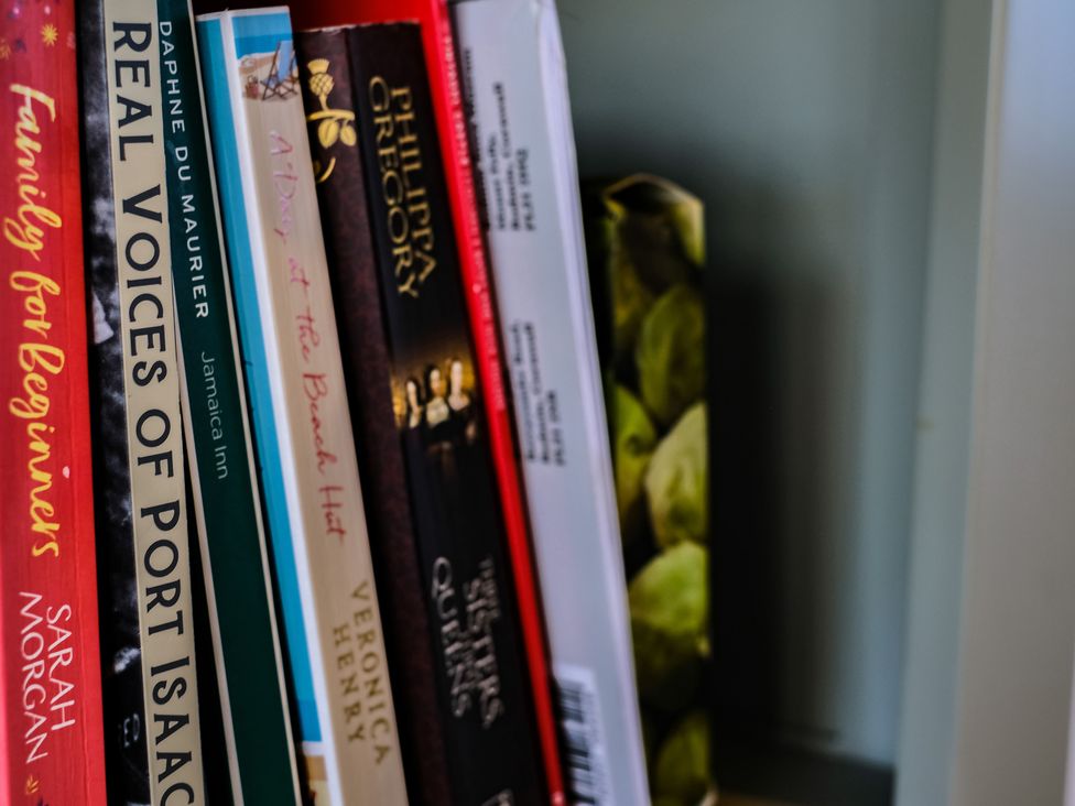 A closeup of books on a shelf including titles by Sarah Morgan Daphne Du Maurier and Veronica Henry at Harbour Lights Port Isaac