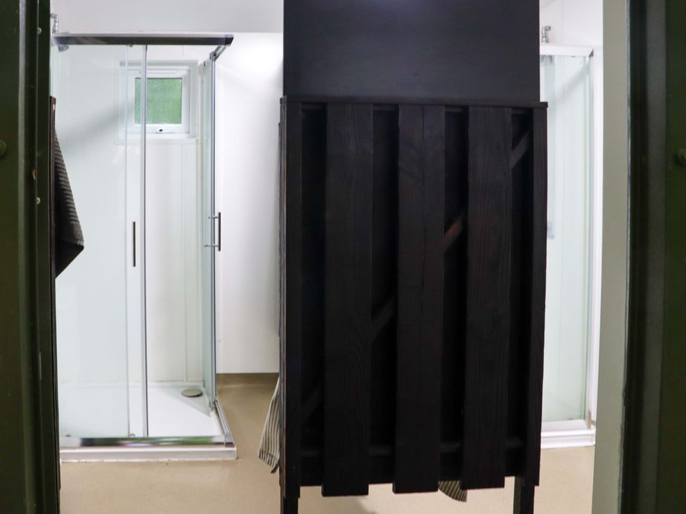 A bathroom with two glass shower cubicles and a dark wooden partition in Ballybeg Pod 10 Ballybeg near Tinahely County Wicklow