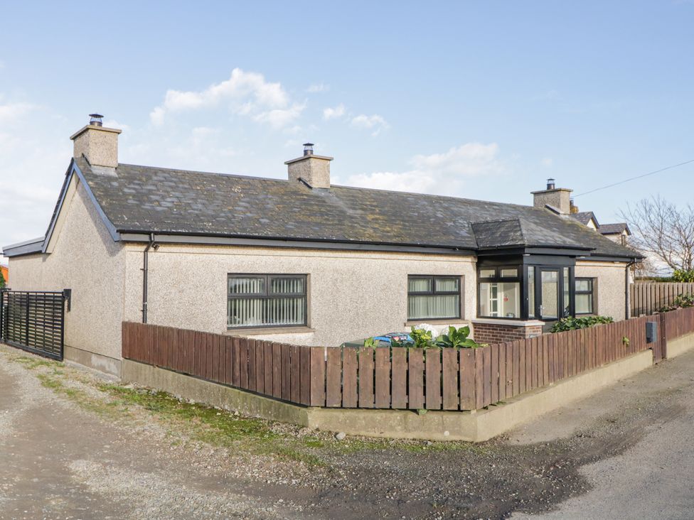 A single story house with a fenced garden and a gravel driveway at Ritas in Greencastle near Kilkeel