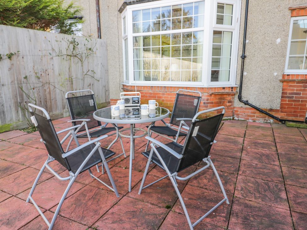 A patio area with a round glass table and four chairs outside a house at Southpoint in Bridlington